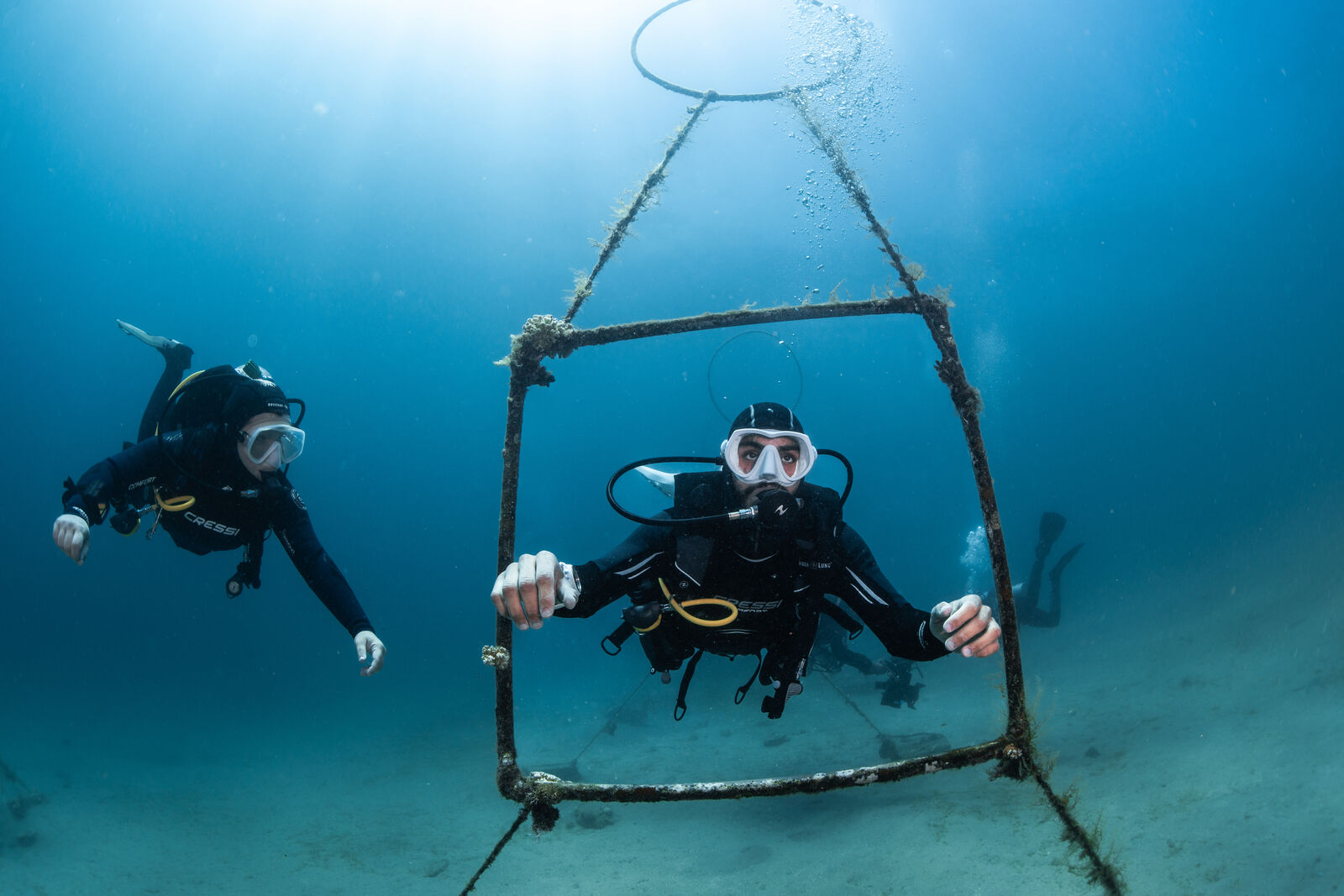 female scuba instructor watching as a male scuba diver practices their buoyancy at dahab's underwater buoyancy park