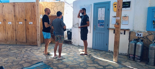 Divers talking together outside the equipment room before a dive