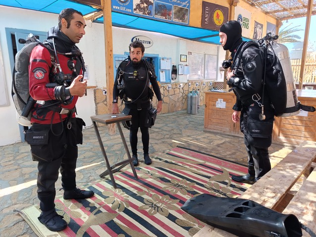 A GUE instructor briefing two divers before a technical dive at Scuba Seekers