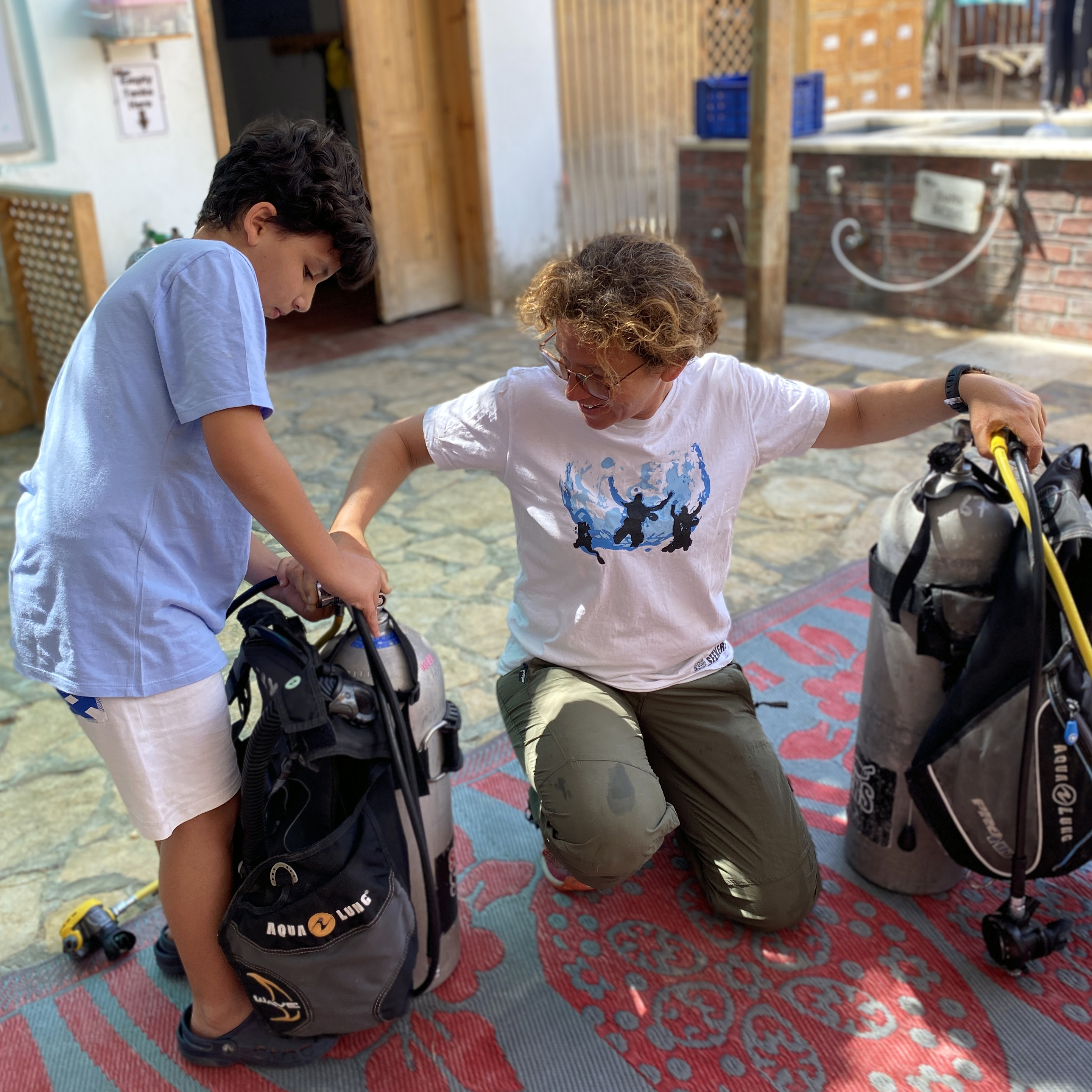 Alex, now an instructor, helping a young student set up his scuba gear at Scuba Seekers in Dahab